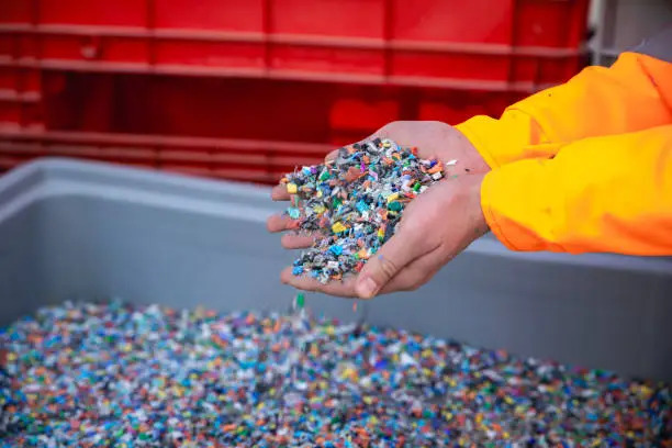 Plastic Resin pellets in holding hands.